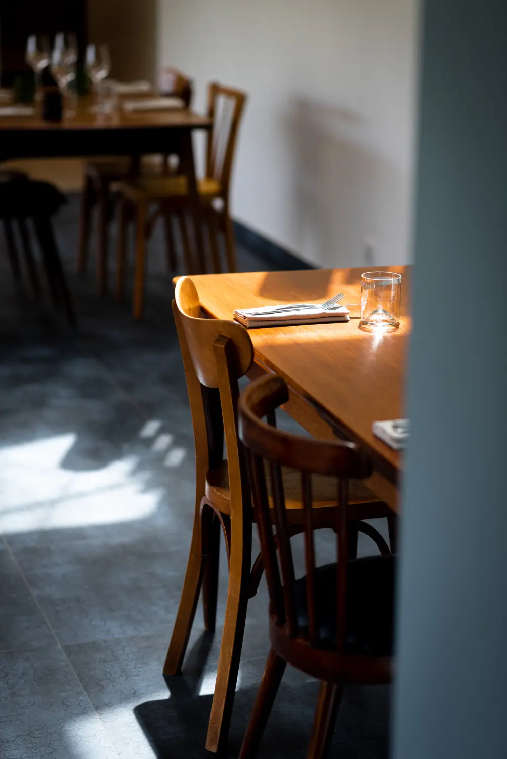 La salle du restaurant Rolland, lumière du soir sur les tables en bois
